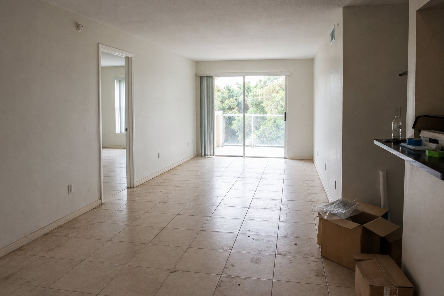 Empty apartment before move-out cleaning with boxes and floor marks